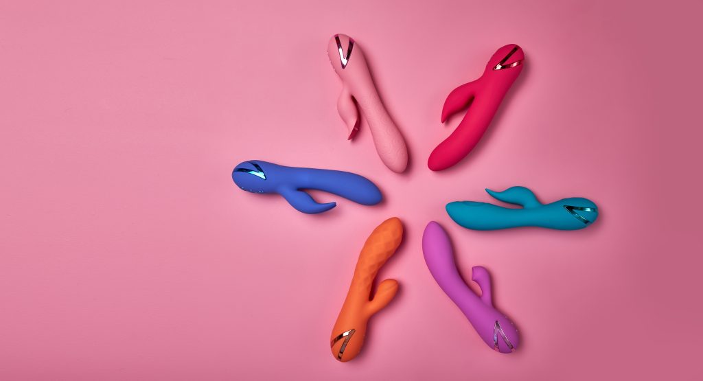 Stimulate Your Most Sensitive Area. Composition Of Colorful G-spot Vibrators Arranged On Pink Paper Background. View From Above. Place For Text. Flat Lay. Sex Shop Concept.
